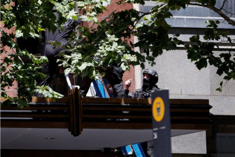 Police use a ladder to evacuate people from a building near Lindt cafe