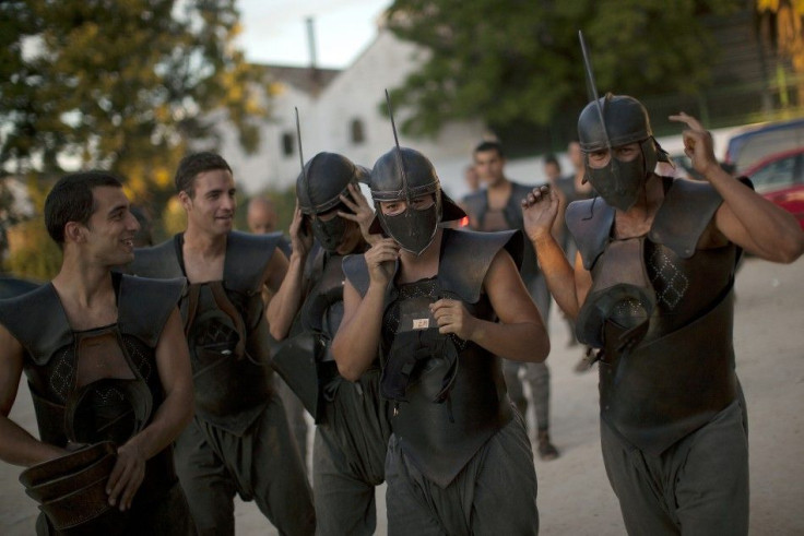 Extras joke as they walk along a street after taking part in the filming of the fifth season of the HBO TV series &quot;Game of Thrones'&quot;