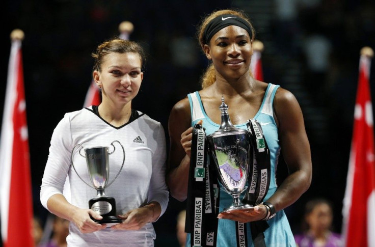 Serena Williams of the U.S. (R) poses with the trophy after defeating Simona Halep of Romania in the women&#039;s singles final tennis match of the WTA Finals at the Singapore Indoor Stadium October 26, 2014.