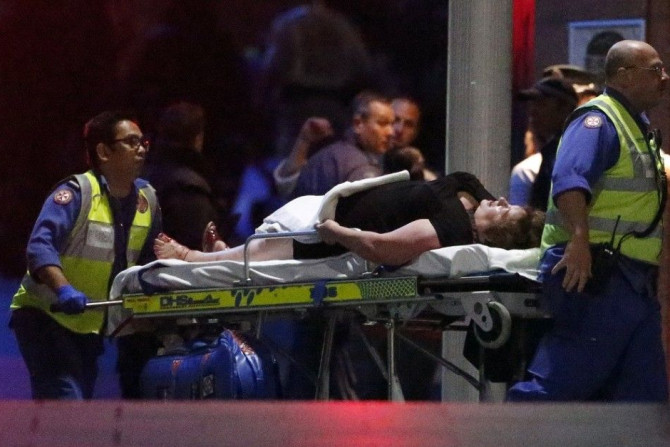 Paramedics remove an injured woman on a stretcher from the Lindt cafe, where hostages were being held, at Martin Place in central Sydney December 16, 2014. Australian security forces on Tuesday stormed the Sydney cafe where several hostages were being hel