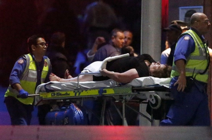 Paramedics remove an injured woman on a stretcher from the Lindt cafe, where hostages were being held, at Martin Place in central Sydney December 16, 2014. Australian security forces on Tuesday stormed the Sydney cafe where several hostages were being hel