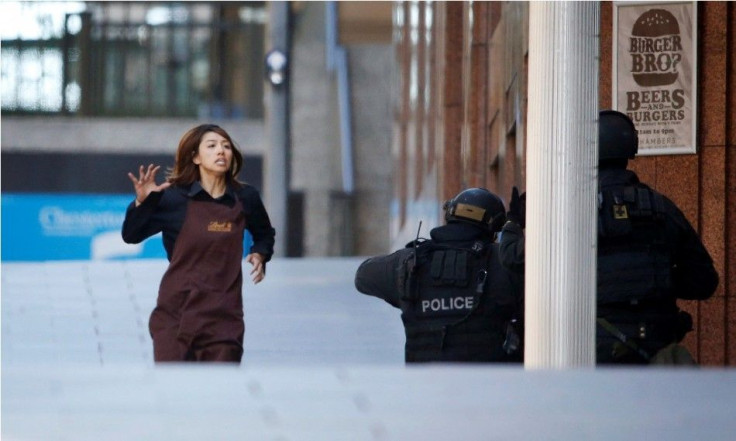 A hostage runs towards a police officer outside Lindt cafe