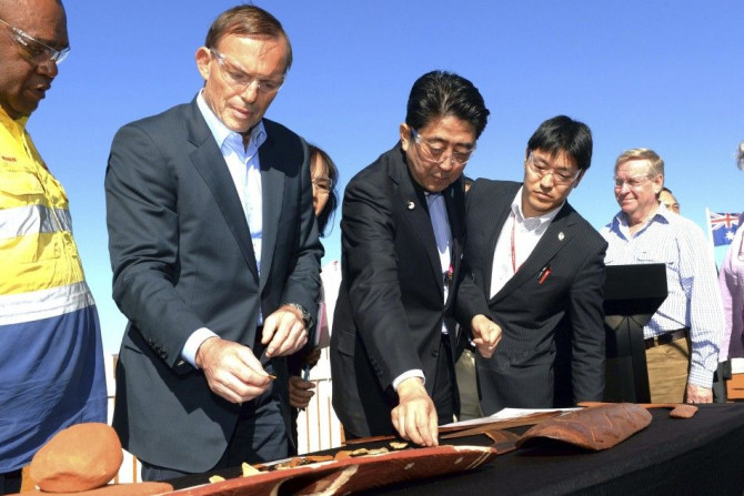 Japanese Prime Minister Shinzo Abe (C) and Australian Prime Minister Tony Abbott (2nd L) examine boomerangs during a tour of the Rio Tinto West Angelas iron ore mine