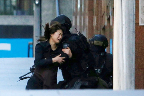 A hostage runs towards a police officer outside Lindt cafe