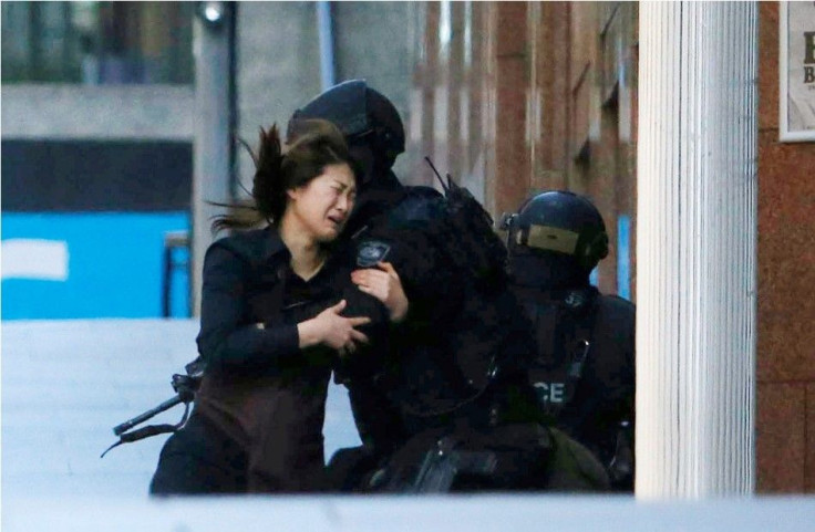 A hostage runs towards a police officer outside Lindt cafe