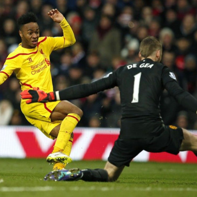 Manchester United goalkeeper David De Gea (R) makes a save from Liverpool's Raheem Sterling during their English Premier League soccer match at Old Trafford in Manchester, northern England December 14, 2014.