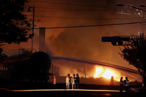 Firefighters look at a train wagon on fire at Lac Megantic, Quebec, July 6, 2013. Canadian police expect the death toll from a fatal fuel train blast in a small Quebec town to be more than the one person confirmed dead so far, a spokesman said on Saturday