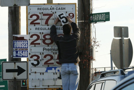 A man changes the price for a gallon of gasoline at a gas station in Medford, Massachusetts December 4, 2014. Brent crude oil fell below $69 a barrel on Thursday after Saudi Arabia announced deep cuts in selling prices for Asian and U.S. buyers, a week af