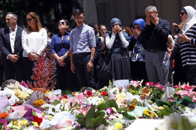 Members of the Australian Muslim community pray after placing floral tributes amongst thousands of others near the Lindt cafe, where hostages were held for over 16-hours, in central Sydney December 16, 2014. Heavily armed Australian police stormed the Syd
