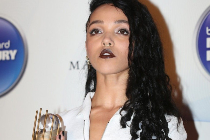 FKA twigs poses with her nominee trophy as she arrives at the 2014 Mercury Prize awards in London