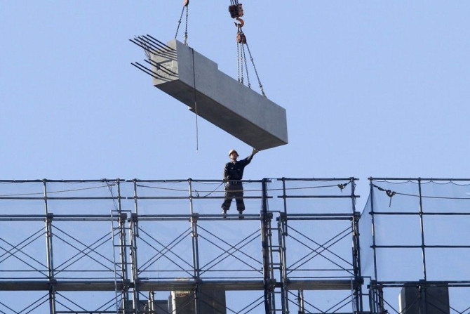 A man works atop of a building constructing site in Tokyo December 15, 2014. Japanese big manufacturers' sentiment worsened slightly in the three months to December but corporate spending plans were strong, a closely watched central bank survey showed, hi