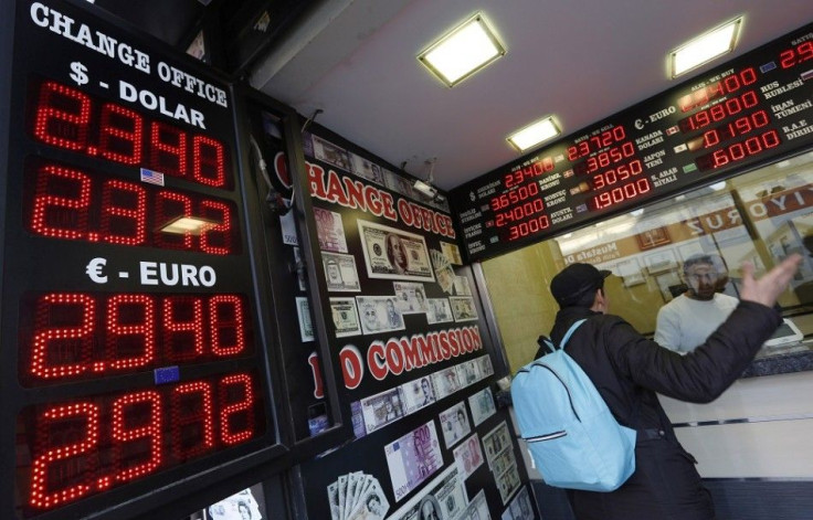 A man checks currency exchange rates at an currency exchange office in Istanbul December 16, 2014. The Turkish lira weakened to a record low of 2.4140 against the dollar on Tuesday after a fall in the value of the ruble in Russia, a fellow emerging market