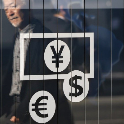 Passers-by are reflected on a signboard displaying currency signs outside a bank in Tokyo November 27, 2014. The dollar edged down against the yen on Thursday after lacklustre U.S. economic data pushed Treasury yields lower and dulled investor appetite fo