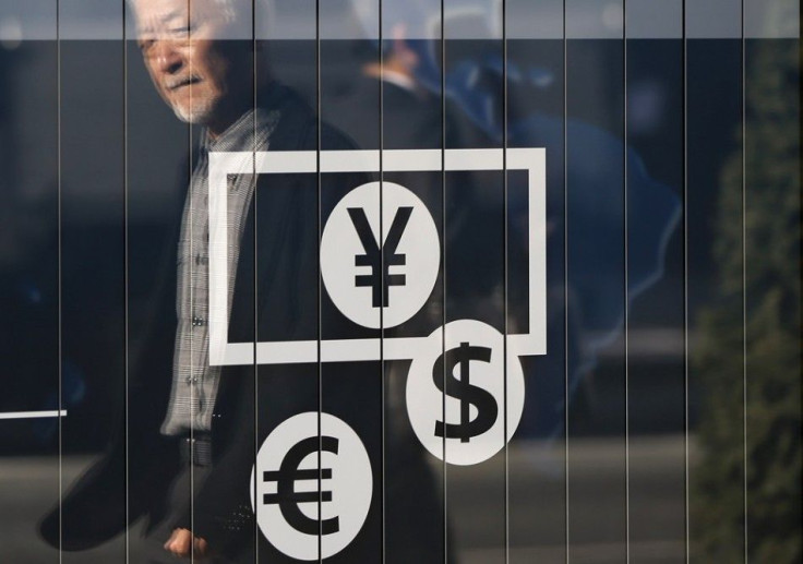 Passers-by are reflected on a signboard displaying currency signs outside a bank in Tokyo November 27, 2014. The dollar edged down against the yen on Thursday after lacklustre U.S. economic data pushed Treasury yields lower and dulled investor appetite fo