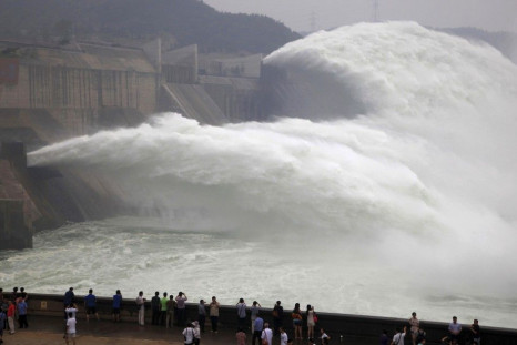 Visitors watch water gushing from the section of the Xiaolangdi Reservoir on the Yellow River, during a sand-washing operation in Jiyuan, Henan province June 22, 2013. Picture taken June 22, 2013. REUTERS/China Daily