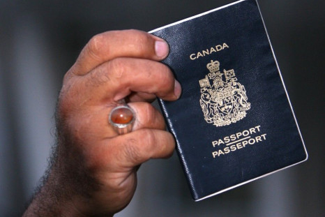 Sami Dia, an evacuee from Lebanon, displays his passport as Canadian passport holders fleeing the conflict in Lebanon arrive at the port of Mersin in Turkey's Mediterranean coastal city July 21, 2006