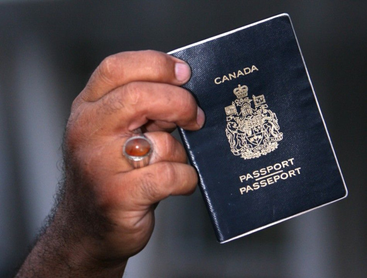 Sami Dia, an evacuee from Lebanon, displays his passport as Canadian passport holders fleeing the conflict in Lebanon arrive at the port of Mersin in Turkey's Mediterranean coastal city July 21, 2006