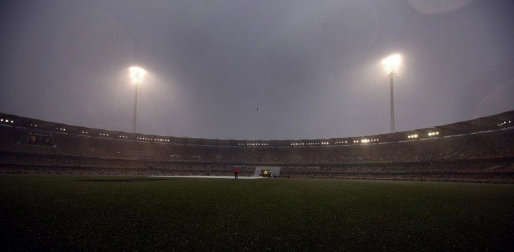 A security officer stands near the pitch in the rain as the match was stopped due to bad weather during the fourth day&#039;s play of the first Ashes cricket test match between England and Australia at the Gabba in Brisbane November 24, 2013.