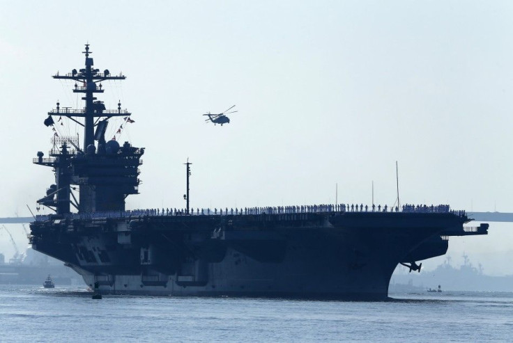 Sailors man the rails of the USS Carl Vinson, a Nimitz-class aircraft carrier, as it departs its home port in San Diego, California August 22, 2014. The aircraft carrier and its strike group, made up of guided-missile cruiser USS Bunker Hill, and guided-m