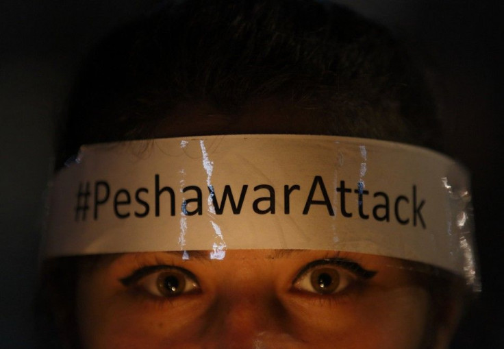 A woman with a headband on her forehead attends a candle light vigil in Kathmandu