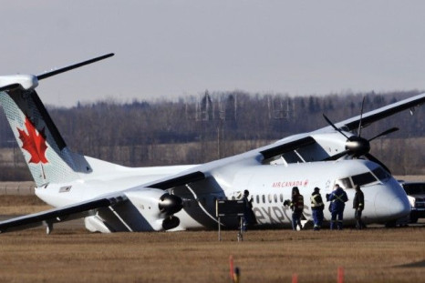 Investigators comb the area around an Air Canada plane on the tarmac of the Edmonton International Airport following an emergency landing several hours prior in Edmonton November 7, 2014. Four people were sent to hospital after a rough landing at Edmonton