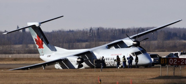 Investigators comb the area around an Air Canada plane on the tarmac of the Edmonton International Airport following an emergency landing several hours prior in Edmonton November 7, 2014. Four people were sent to hospital after a rough landing at Edmonton