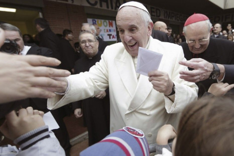 Pope Francis holds a letter received from a child as he arrives to visit the Saint Joseph at Aurelio church in Rome December 14, 2014. REUTERS/Yara Nardi