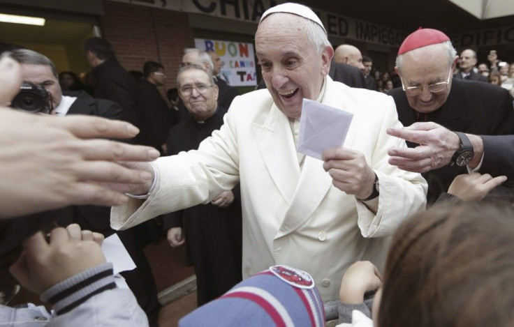 Pope Francis holds a letter received from a child as he arrives to visit the Saint Joseph at Aurelio church in Rome December 14, 2014. REUTERS/Yara Nardi