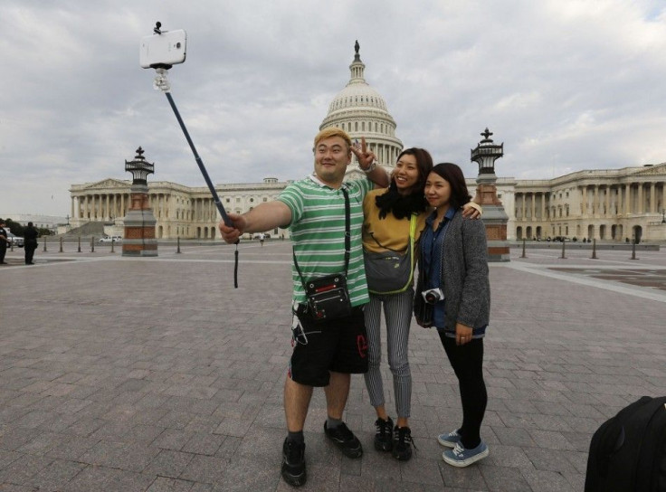 South Korean tourists (L-R) Heemok Ann, Eunyi Ji, and Mijung Jung take their own picture in front of the U.S. Capitol dome on Capitol Hill in Washington after the U.S. government shutdown, October 1, 2013. The U.S. government began a partial shutdown on T