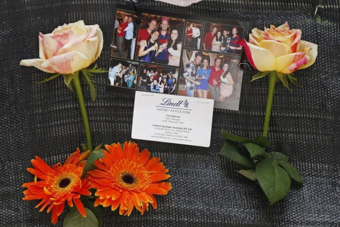 A business card bearing the name of Sydney siege victim, Lindt Cafe store manager Tori Johnson, is pictured among photos of him wearing a red shirt at an impromptu memorial in Martin Place December 17, 2014. Tough new national security laws failed to prev