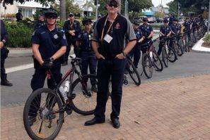Police stand with their bicycles as they watch a small protest outside the venue of the G20 finance ministers and central bankers in the northern Australian city of Cairns