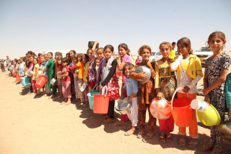 Displaced people from the minority Yazidi sect, fleeing violence in the Iraqi town of Sinjar west of Mosul, line up to receive food at the khanki camp on the outskirts of Dohuk province, September 13, 2014. REUTERS/Ari Jalal