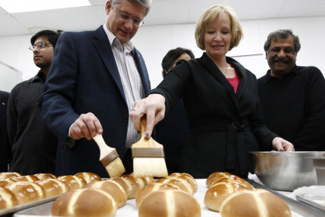 Conservative leader and Canada&#039;s Prime Minister Stephen Harper and his wife Laureen glaze hot cross buns during a campaign stop at a bakery in Mississauga, Ontario April 23, 2011. Canadians will head to the polls in a federal election on May 2. REUTE