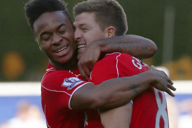 Liverpool&#039;s Raheem Sterling (L) celebrates with Steven Gerrard after his cross led to the winning own goal during their English Premier League soccer match against Queens Park Rangers at Loftus Road in London October 19, 2014.