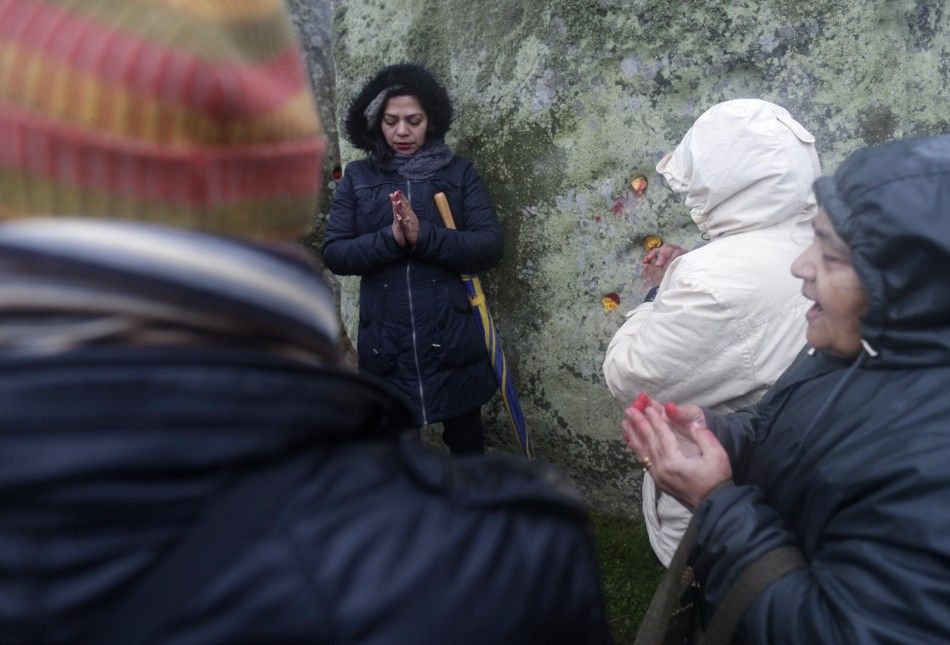 Revellers pray as they celebrate the winter solstice at Stonehenge in Amesbury, southern England December 21, 2013