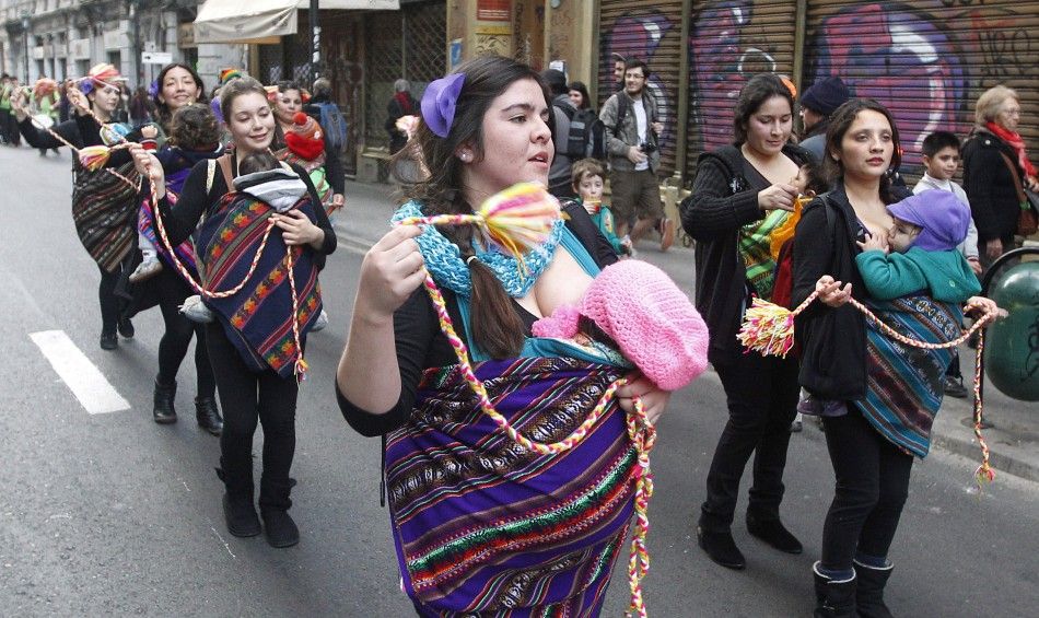 Mothers from a folkloric group hold their children as they accompany performers during a ritual dance known as quottinkuquot during celebrations of the indigenous New Year in Valparaiso city, June 21, 2014.