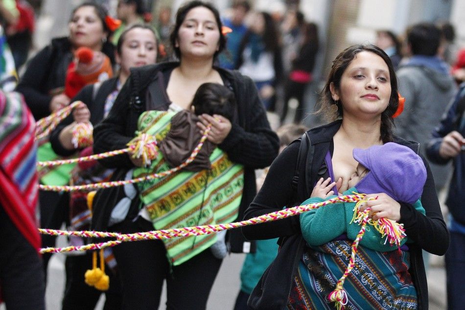 Mothers from a folkloric group hold their children as they accompany performers during a ritual dance known as quottinkuquot during celebrations of the indigenous New Year in Valparaiso city, June 21, 2014. 