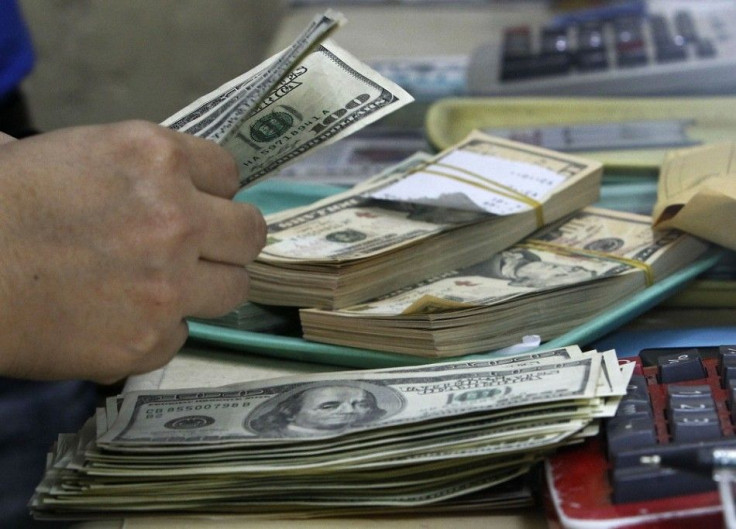 An employee counts U.S. dollar bills before changing it to Philippine Pesos inside a money changer in Manila September 19, 2013. The Philippine central bank said on Thursday it would keep intervening in the market to manage wild swings as the peso jumped 