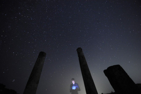A photographer looks at his camera during the Perseid meteor shower at Stobi archeological site, which was the largest city in the northern part of the Roman province Macedonia and later capital city of the Roman province Macedonia Secunda, early August 1
