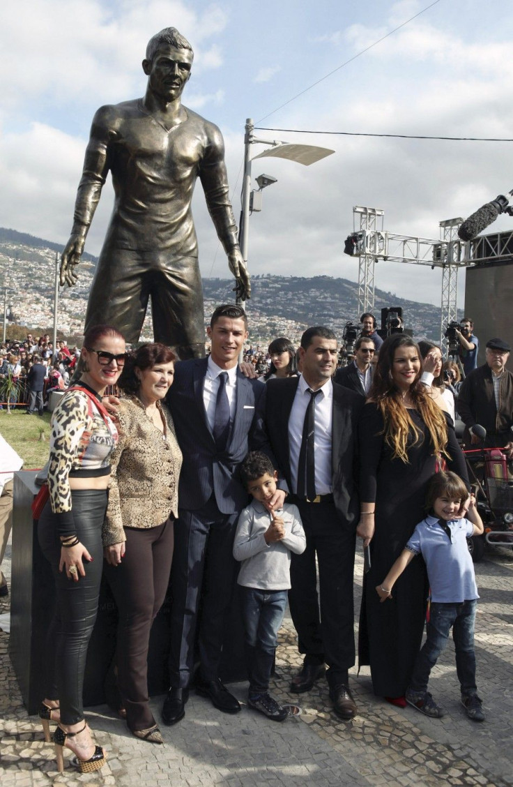 Portugal&#039;s Cristiano Ronaldo (C) and his family members pose under his statue during the unveiling of the statue at a tribute ceremony held in his city of birth, in Funchal December 21, 2014. REUTERS/Duarte Sa