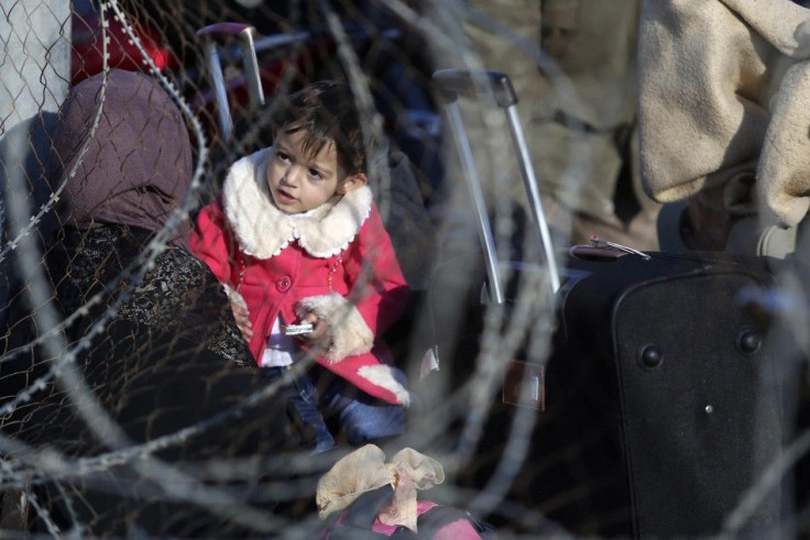 A Palestinian girl, hoping to cross into Egypt with her mother, is pictured through a fence