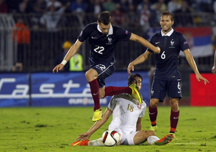 Morgan Schneiderlin of France (L) jumps over Filip Djuricic of Serbia during their friendly soccer match in Belgrade September 7, 2014.