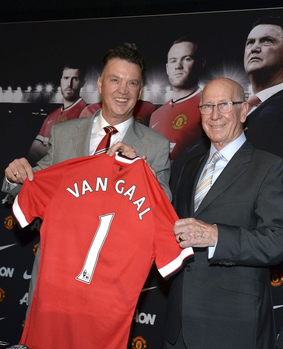 New Manchester United manager Louis Van Gaal L poses for pictures with club director Bobby Charlton during a news conference at the clubs Old Trafford Stadium in Manchester, northern England, July 17, 2014.