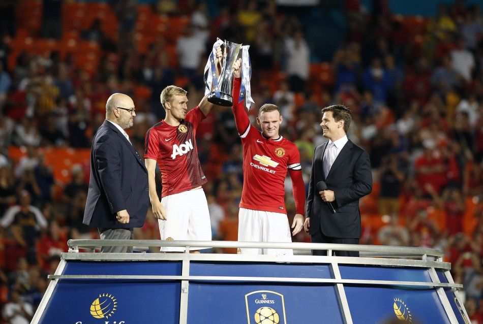 Miami Gardens, FL, USA Manchester United forward Wayne Rooney right holds the championship trophy with midfielder Darren Fletcher left after defeating Liverpool 3-1 at Sun Life Stadium. 