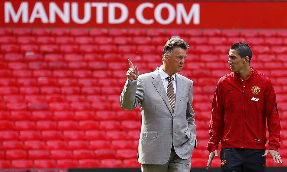 Manchester Uniteds new signing Angel Di Maria R speaks with manager Louis van Gaal as he arrives for a news conference at Old Trafford in Manchester, northern England August 28, 2014.