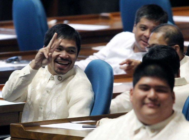 Newly elected Philippine congressman and world boxing champion Manny Pacquiao gives a peace sign after he votes for the new Speaker during the opening of the 15th Philippine Congress in Quezon City, Metro Manila July 26, 2010. Philippine President Benigno