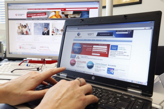 An employee of French National Agency for Employment (Pole Emploi) works simultaneously on French and German agencies for employement internet sites, at the joint German-French job center office in Kehl, Germany, on the French-German border near Strasbour