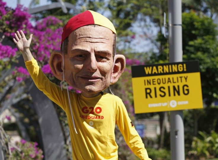 A protester, wearing a mask depicting Australian Prime Minister Tony Abbott, calls for global equality among nations outside the venue site of the annual G20 leaders summit in Brisbane, November 14, 2014. Leaders of the top 20 industrialized nations will 