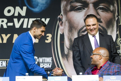Welterweight boxer Amir Khan (L) of Britain greets Leonard Ellerbe, CEO of Mayweather Promotions, as Richard Schaefer, CEO of Golden Boy Promotions, looks on during a news conference for undercard boxers at the MGM Grand Hotel and Casino in Las Vegas, Nev