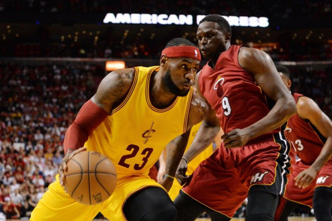 Dec 25, 2014; Miami, FL, USA; Cleveland Cavaliers forward LeBron James (23) drives to the basket around Miami Heat forward Luol Deng (9) during the first half at American Airlines Arena.